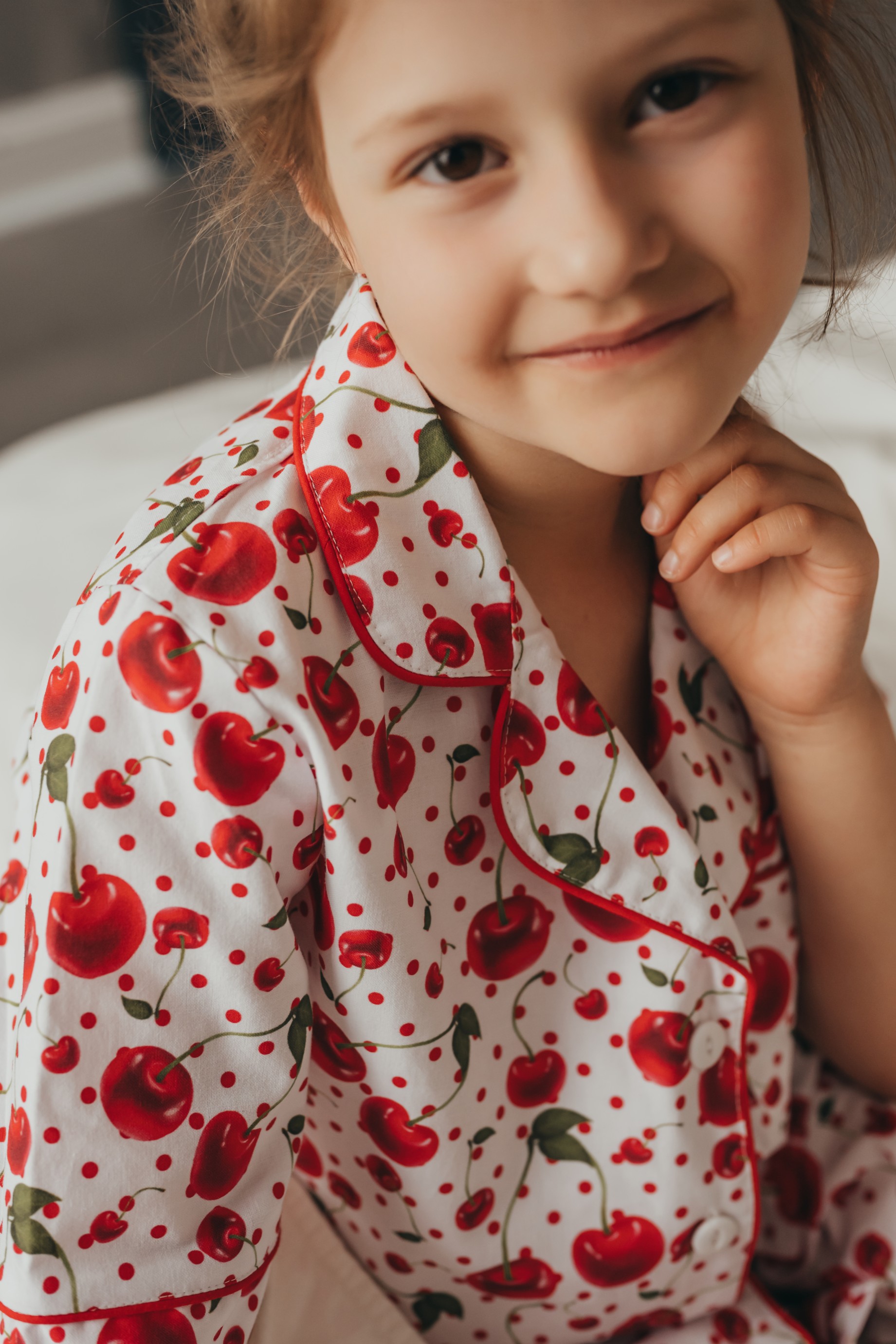 chlopczyk w pizamce blekitnej z len i bawelna na bezowej sofie.